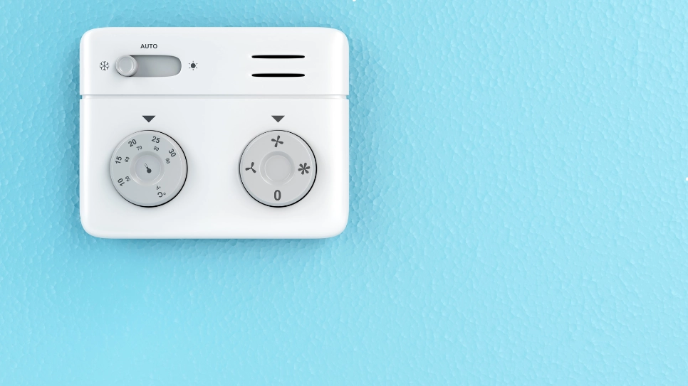 Minimalist wall-mounted air conditioning thermostat with temperature and fan controls, designed for efficient cooling.