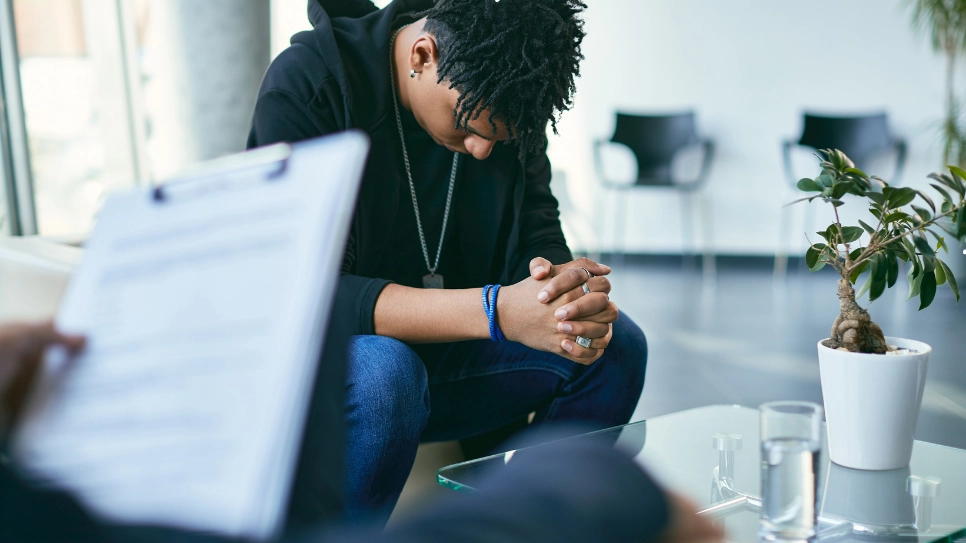 A distressed individual in a therapy session with a counselor, highlighting support for anxiety management and mental health care.