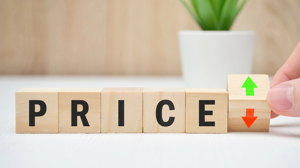 Wooden blocks with letters that form the word price. With a green up arrow and a red down arrow.