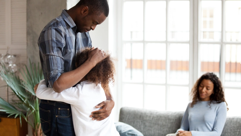 A family sharing a supportive moment, representing care and understanding during child custody discussions.