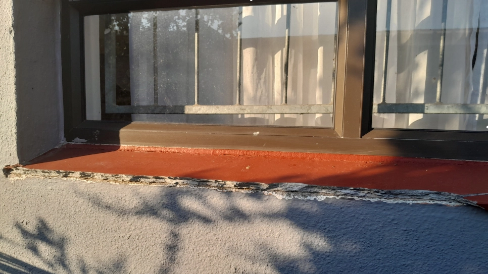 An old cracked window sill of a house.