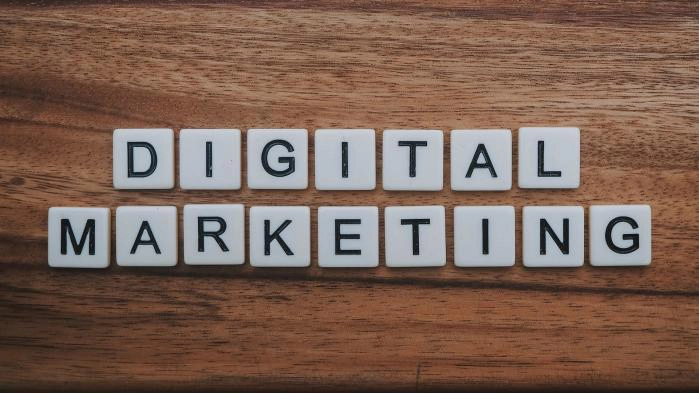 Blocks of letters that form digital marketing on a wooden surface.