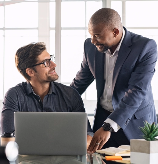 Manager providing guidance to an employee in a collaborative office environment, enhancing employee engagement and support.