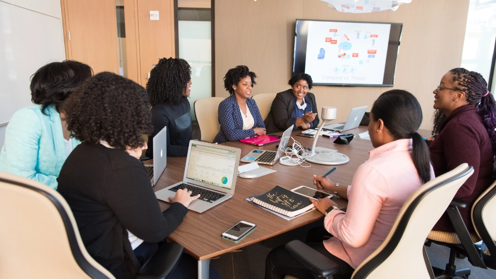 Diverse team collaborating on business strategy in a conference room, fostering strong employee relations and teamwork.