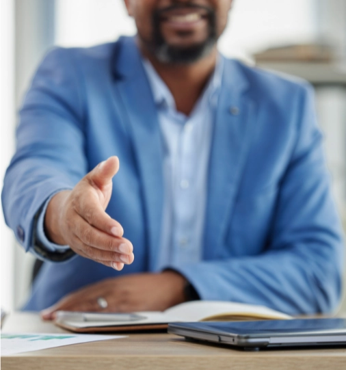 HR recruiter extending a welcoming handshake during a job interview, reflecting a positive approach in the recruitment process.