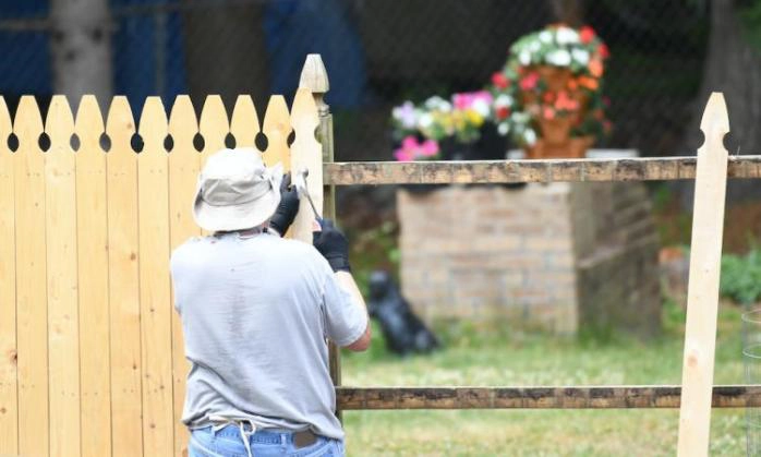 Fence provider installing wooden fence.