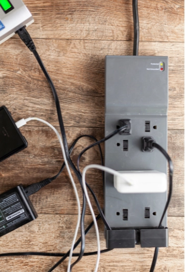 Surge protector with multiple devices plugged in, ensuring protection against electrical surges for safe device charging.