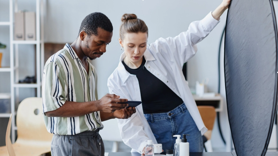 Photographers arranging lighting and props for a product photoshoot, focusing on capturing high-quality product images.