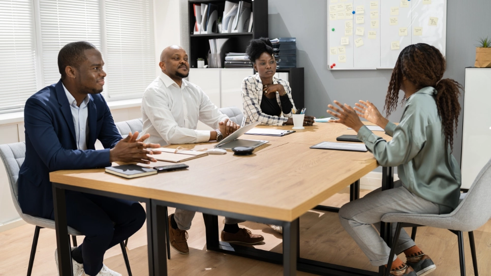 Professional team interviewing a candidate in a modern office setting, fostering a collaborative recruitment process.