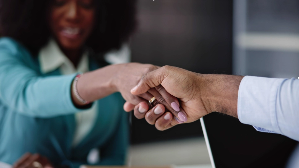 Close-up of a handshake between a recruiter and a candidate, symbolizing agreement and positive interaction.