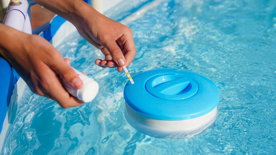 A person using a test strip to check chlorine levels in pool water, ensuring safe and balanced water chemistry.