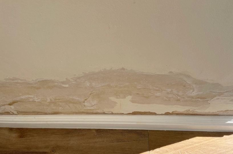 Visible water damage on a wall near the baseboard, indicating potential moisture issues.