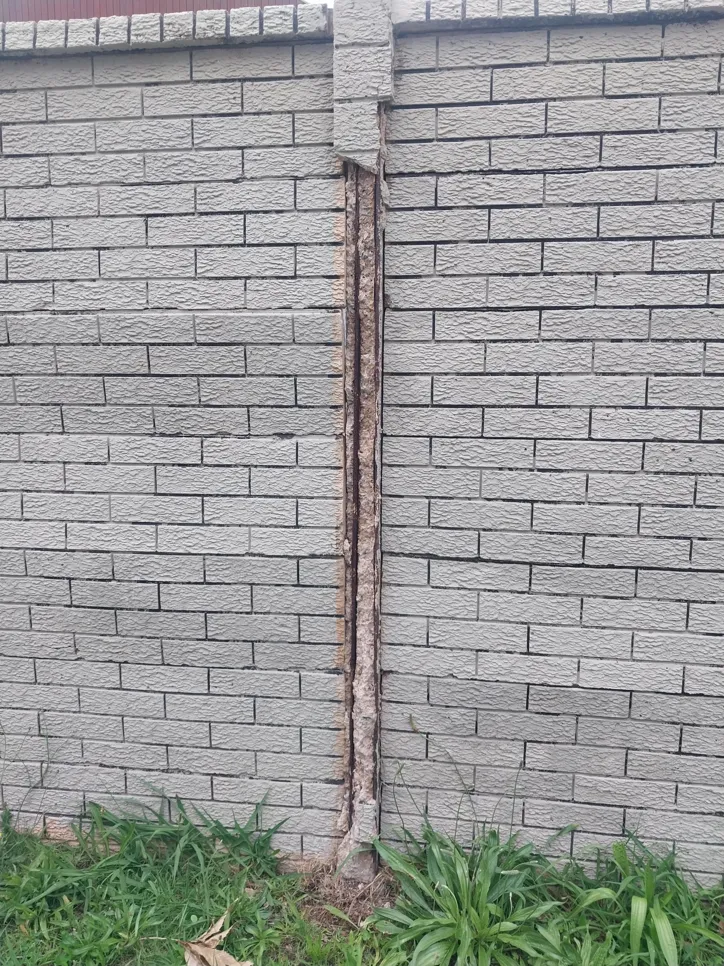 Cracked brick wall Vertical crack in a brick wall indicating structural damage or foundation issues.